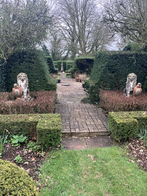 Lot 543 - A pair of composition stone figures of seated lions