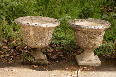 Lot 570 - A pair of composition stone urns